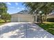 Charming single-story home with a three-car garage, landscaped yard, and a welcoming entrance at 4712 Charles Partin Dr, Parrish, FL 34219