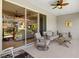 Relaxing lanai with neutral furniture, ceiling fan, and view through sliding glass doors to the home's interior at 4712 Charles Partin Dr, Parrish, FL 34219