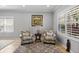 Living room featuring neutral paint, tile flooring, plantation shutters, and comfortable seating with stylish furnishings at 4712 Charles Partin Dr, Parrish, FL 34219