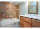 Bathroom featuring a tiled shower with a bathtub and a wooden vanity with marble countertop at 4812 Kestral Park Cir # 20, Sarasota, FL 34231