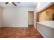 Living room featuring terra-cotta tile flooring, a ceiling fan, and kitchen access with pass-through at 4812 Kestral Park Cir # 20, Sarasota, FL 34231