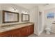 Bathroom with dual sinks, granite countertops, a walk-in shower, and a toilet at 4907 4Th Avenue Nw Cir, Bradenton, FL 34209