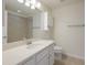 Bright bathroom featuring a large mirror, white vanity with stone countertop, and a tiled shower/tub combo at 5237 Blossom Cv, Lakewood Ranch, FL 34211