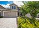Charming two-story home showcasing a well-manicured lawn and a paved driveway leading to a two-car garage at 5237 Blossom Cv, Lakewood Ranch, FL 34211