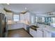 Well-lit kitchen with stainless steel appliances, white cabinetry, and a view to the living room at 5301 Bartolomeo St, Sarasota, FL 34238