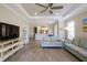 Open living room featuring tile floors, ceiling fan, television and access to the kitchen at 5301 Bartolomeo St, Sarasota, FL 34238