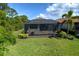 A screened-in lanai with paved patio and comfortable seating overlooks the manicured lawn and landscaping at 5301 Bartolomeo St, Sarasota, FL 34238
