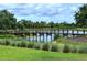 Scenic wooden bridge over a tranquil pond with lush greenery and a blue sky backdrop at 5301 Bartolomeo St, Sarasota, FL 34238