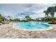 Resort-style pool with plenty of lounge chairs and umbrellas surrounded by lush, tropical landscaping at 5301 Bartolomeo St, Sarasota, FL 34238