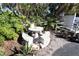 Charming outdoor seating area with mosaic table and benches, surrounded by lush tropical foliage at 5877 17Th W St # B4, Bradenton, FL 34207