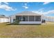 Expansive backyard featuring a screened-in lanai, green lawn, and a well-maintained exterior at 5909 33Rd E Dr, Palmetto, FL 34221