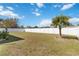 Spacious backyard with lush grass, a white privacy fence, and a mature palm tree at 5909 33Rd E Dr, Palmetto, FL 34221