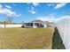Large backyard with white vinyl fence, a screened-in lanai and well-kept lawn at 5909 33Rd E Dr, Palmetto, FL 34221