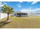Spacious backyard featuring a well-maintained lawn, palm tree, and white vinyl fence at 5909 33Rd E Dr, Palmetto, FL 34221