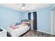 Light blue bedroom features luxury vinyl floors, a ceiling fan, and black-out curtains at 5909 33Rd E Dr, Palmetto, FL 34221