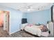 A blue bedroom features luxury vinyl floors, a ceiling fan, and a TV stand at 5909 33Rd E Dr, Palmetto, FL 34221