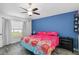 Bedroom with vaulted ceiling, ceiling fan, wood-look floors, blue accent wall, and bright natural light at 5909 33Rd E Dr, Palmetto, FL 34221