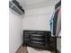 Walk-in closet with modern black dresser, closet organization system, and wood-look floors at 5909 33Rd E Dr, Palmetto, FL 34221