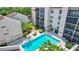 Aerial view showcases the building's exterior, community pool, landscaping, and nearby amenities at 6157 Midnight Pass Rd # E65, Sarasota, FL 34242