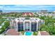 Aerial image of the condo building with a view of the community pool and the nearby ocean at 6157 Midnight Pass Rd # E65, Sarasota, FL 34242