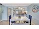 Bright dining room features modern table, chairs, and a pass-through to the kitchen area with updated lighting at 6157 Midnight Pass Rd # E65, Sarasota, FL 34242
