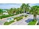 Landscaped community entrance with palm trees, a sign, and well-maintained shrubbery at 6157 Midnight Pass Rd # E65, Sarasota, FL 34242