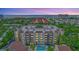 Stunning aerial view of a condo building with a pool and close proximity to the beach at 6157 Midnight Pass Rd # E65, Sarasota, FL 34242