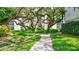 Inviting landscaped walkway with mature trees and lush greenery surrounding a well-maintained building at 6157 Midnight Pass Rd # E65, Sarasota, FL 34242