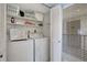Bright laundry room featuring a washer, dryer, shelving, and plenty of storage space at 6157 Midnight Pass Rd # E65, Sarasota, FL 34242
