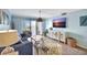 Cozy living room featuring stylish furniture, a large TV, and sliding glass doors to the balcony at 6157 Midnight Pass Rd # E65, Sarasota, FL 34242
