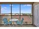 Enclosed patio with blue chairs and table, providing a relaxing outdoor space to enjoy the neighborhood views at 6157 Midnight Pass Rd # E65, Sarasota, FL 34242