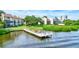 Waterfront view of community, condo buildings, pier, and mature trees at 6157 Midnight Pass Rd # E65, Sarasota, FL 34242