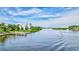 Beautiful waterfront view with boat, pier, and lush landscaping in a serene neighborhood at 6157 Midnight Pass Rd # E65, Sarasota, FL 34242