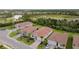 Residential area featuring homes with red tile roofs, landscaping, and a scenic pond in the background at 620 Nasturtium Ct, Nokomis, FL 34275