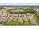 An aerial view shows a large residential neighborhood with lush green trees, sidewalks, and a pond nearby at 620 Nasturtium Ct, Nokomis, FL 34275