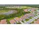 An aerial view shows a residential neighborhood with lush green trees, sidewalks, and a pond nearby at 620 Nasturtium Ct, Nokomis, FL 34275