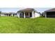 Picture of a house backyard featuring a covered patio and lush green lawn, perfect for outdoor entertaining at 620 Nasturtium Ct, Nokomis, FL 34275