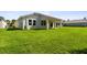 A large, well-maintained green backyard. The covered patio provides an ideal outdoor space for relaxation and entertainment at 620 Nasturtium Ct, Nokomis, FL 34275