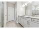 Bright bathroom featuring a double sink vanity, white cabinets, and glass enclosed shower at 620 Nasturtium Ct, Nokomis, FL 34275