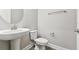 Powder room features pedestal sink and grey plank flooring at 620 Nasturtium Ct, Nokomis, FL 34275