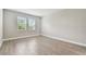 Bright bedroom with wood-look tile flooring and two windows providing natural light at 620 Nasturtium Ct, Nokomis, FL 34275