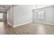 Dining room features wood-look tile flooring, gray paint, white baseboards, a door, and a bright window at 620 Nasturtium Ct, Nokomis, FL 34275
