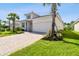 A well-maintained one-story house featuring a brick-paved driveway, a two-car garage, and healthy landscaping at 620 Nasturtium Ct, Nokomis, FL 34275