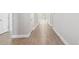 An empty hallway displays wood-look tile floors, white trim, and neutral walls creating a bright and clean atmosphere at 620 Nasturtium Ct, Nokomis, FL 34275