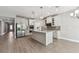 Spacious open-concept kitchen with stainless steel appliances, a center island, and wood-look flooring at 620 Nasturtium Ct, Nokomis, FL 34275