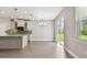 Bright open-concept kitchen and dining area with gray tile flooring, stainless steel appliances and a view of the backyard at 620 Nasturtium Ct, Nokomis, FL 34275