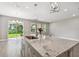 Open kitchen with an island, sink, pendant lighting, and sliding doors to the backyard at 620 Nasturtium Ct, Nokomis, FL 34275