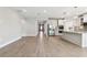 Bright open-concept space with gray tile flooring, flows into the kitchen with stainless steel appliances and a center island at 620 Nasturtium Ct, Nokomis, FL 34275