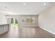 Bright open-concept living space with gray tile flooring, a sliding glass door and three windows at 620 Nasturtium Ct, Nokomis, FL 34275