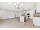 Bright open-concept space with gray tile flooring, flows into the kitchen with stainless steel appliances and a center island at 620 Nasturtium Ct, Nokomis, FL 34275